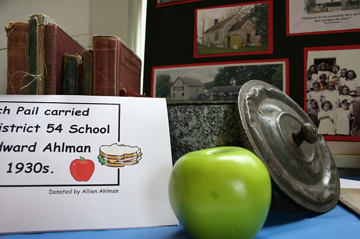 A display of school-related items includes a lunch pail.