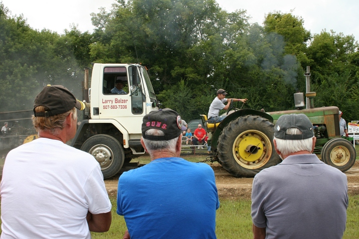 The wheels on the tractor go round and round at the tractor pull.