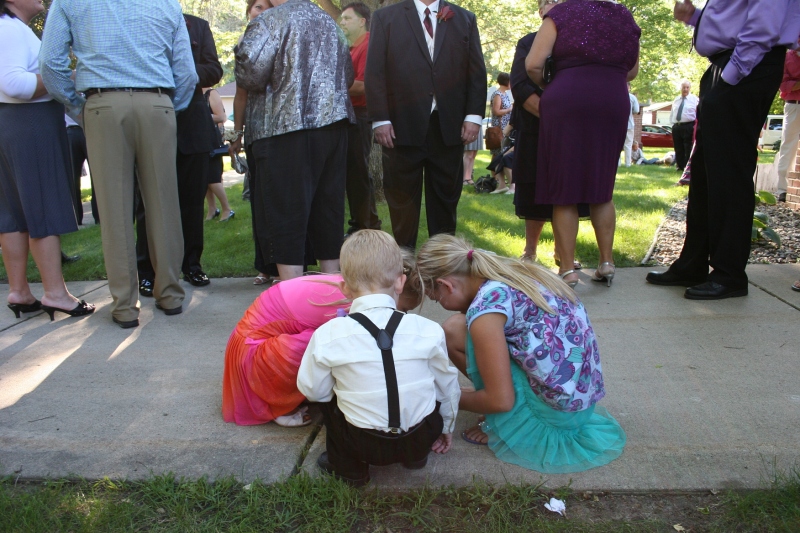 Two wedding guests and ringbearer Hank gathered on the church sidewalk next to the receiving line.