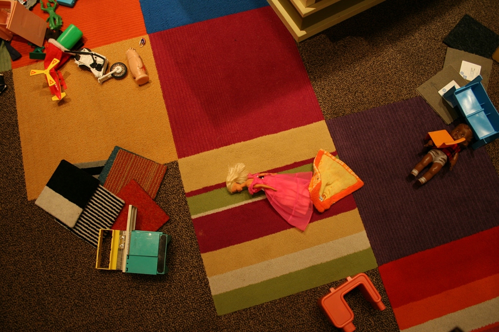Toys strewn across the floor in a play area of the 1970s part of the exhibit.