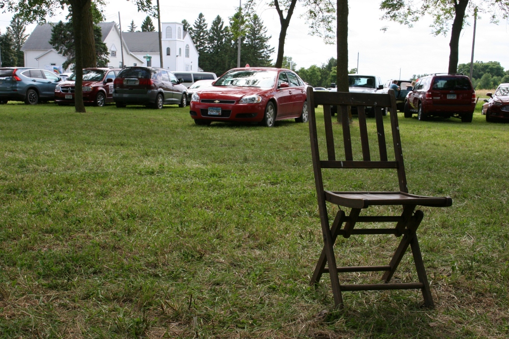 A fest-goer left this vintage wooden folding chair sitting behind the ice cream stand. In the background you can see Trinity Lutheran Church and School across the road.